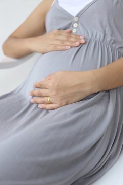 Pregnant women put his hand on her belly.