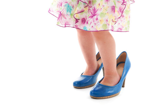 Toddler girl in mothers big shoes