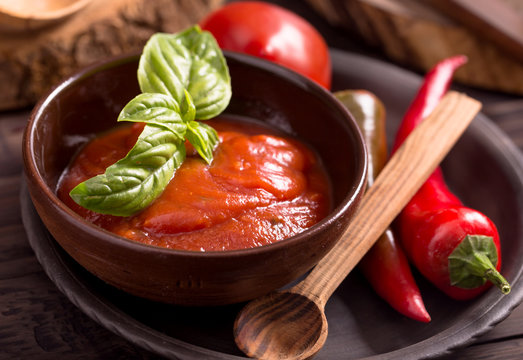 Bowl of tomato sauce and wooden spoon
