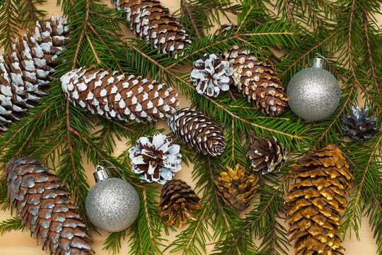 Background from fir-tree branches, Christmas toys and colored cones