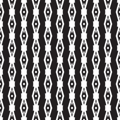 Abstract seamless pattern in black and white.
Hand drawn ornamental wallpaper or textile pattern with white motives on black background.
