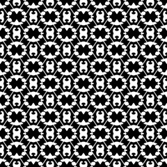 Abstract seamless pattern in black and white.
Hand drawn ornamental wallpaper or textile pattern with white motives on black background.