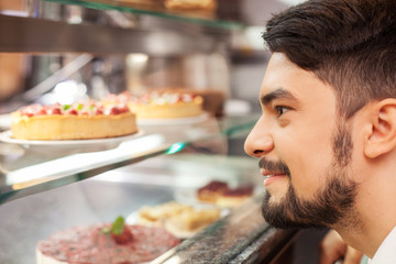 Attractive young guy is buying sweet food