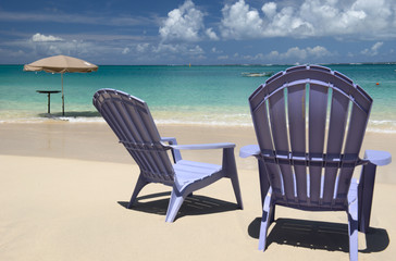 Chairs and umbrella at Grand Case beach, Saint Martin, Caribbean sea