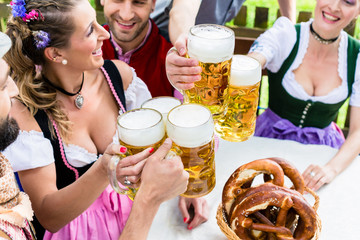 Anstoßen mit drei Maß Helles im Biergarten, Close-up auf die Biergläser