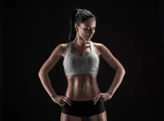 Foto op Plexiglas aantrekkelijke fitnessvrouw, getraind vrouwelijk lichaam, levensstijlportret © bondarchik