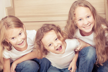 Portrait of happy children which are sitting on the stairs in th