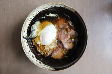 Noodle with pork and egg on wood background