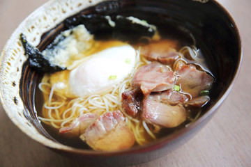 Noodle with pork and egg on wood background