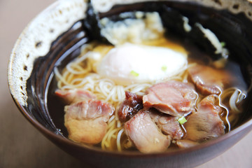 Noodle with pork and egg on wood background