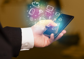 Hand holding smartphone with media icons