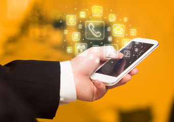 Hand holding smartphone with mobile app icons