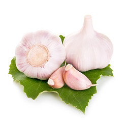 Garlic on green leaf close-up isolated on a white background
