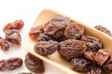 Raisins in a wooden spoon.