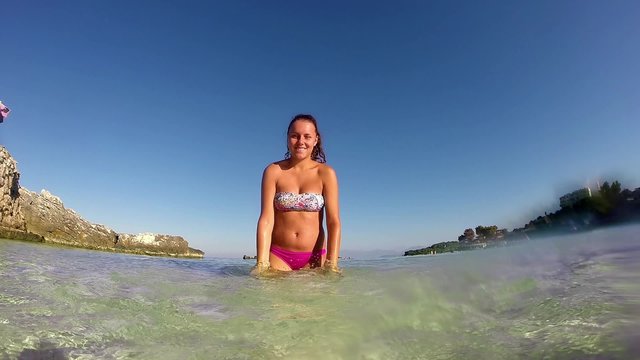 SLOW MOTION: beautiful happy  girl splashing water at summer sea beach