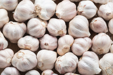 Garlic on the wooden background, top view.