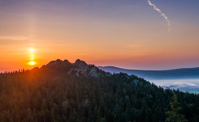 the solar disk rises over the mountain