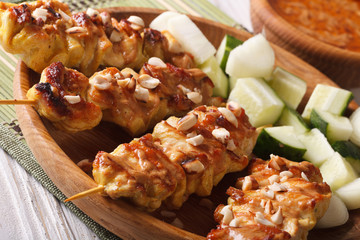 Chicken satay with peanut sauce on a plate macro. horizontal