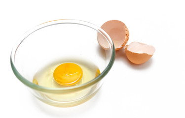 raw eggs yolk in a glass bowl on a white background.