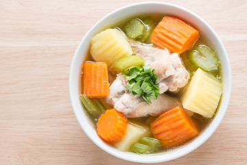 Chicken soup on wood background.