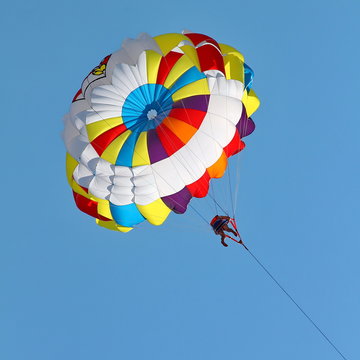 Parasailing in a blue sky.