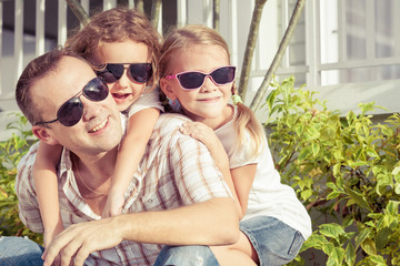 Dad and children playing near a house at the day time.