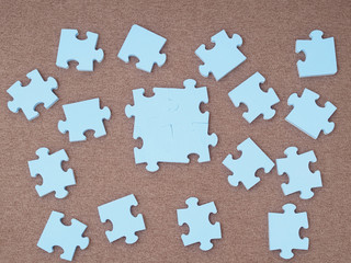 Concept of blue puzzle pieces on brown background