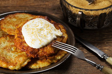 Homemade potato pancakes served with sour cream and brown sugar