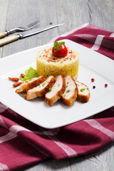 Portion of risotto with roasted chicken.