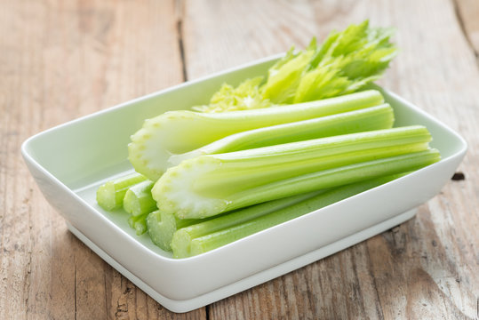 Fresh celery stick on white dish.