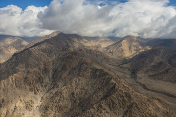 Aerial view of desert and high mountain from the airplane window. New Delhi-Leh flight ,India.