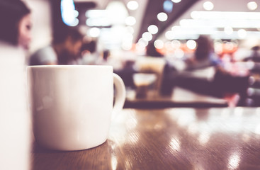 Coffee cup on wood table in cafe with blur background, Leisure l