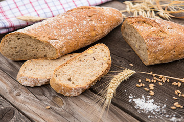 Rustic bread and wheat on an old vintage planked wood table.