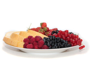 A plate of fruits: melon, strawberries, black currants, red currants, bilberries and raspberries.
