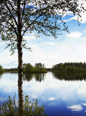 Amazing scenery from Finland. Water and forest with reflections. Image has a vintage effect applied.