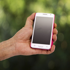 hand holding mobile phone with green background