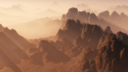 Aerial view of rough mountain landscape in the mist at sunrise.