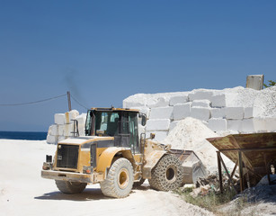 Bulldozer at marble quarry on island