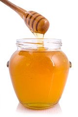 Honey dropping from dipper into a jar
