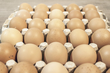 A lot of eggs in carton package on a wooden table for baking