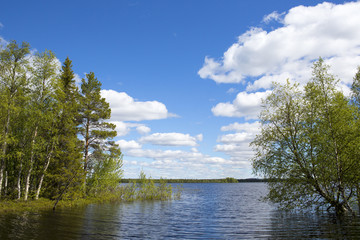 A beautiful scene in Finland in the summer time. Some clouds in the sky giving a deep contrast to the image.