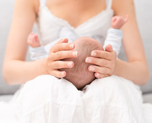 Fototapeta na wymiar Mother is holding newborn baby on her knees.