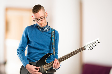 Young man playing guitar over white background