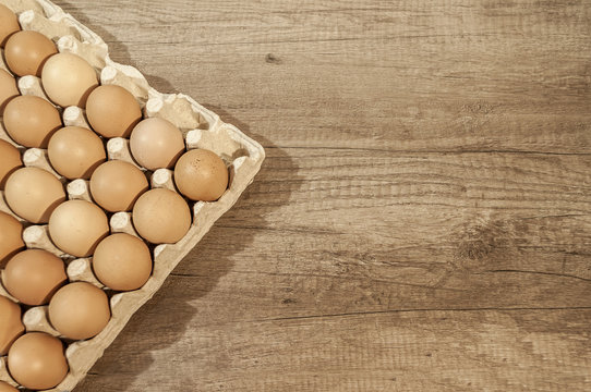 Close up eggs in carton package on a wooden table for baking