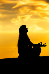 Woman meditating in a yoga pose outdoor