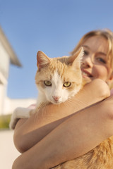Beautiful blond young woman with ginger cat