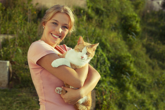 Beautiful Blond Young Woman With Ginger Cat