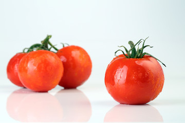Cool fresh tomatoes isolated on white background.