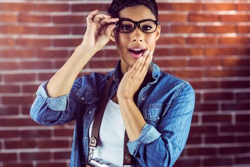 Gorgeous hipster with arm crossed posing with glasses