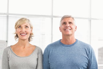 Smiling business colleagues looking above